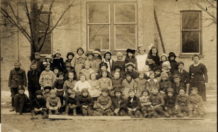 group of children and their teacher from 1920