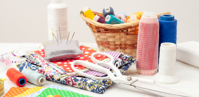 Assorted sewing supplies arranged on a table top.