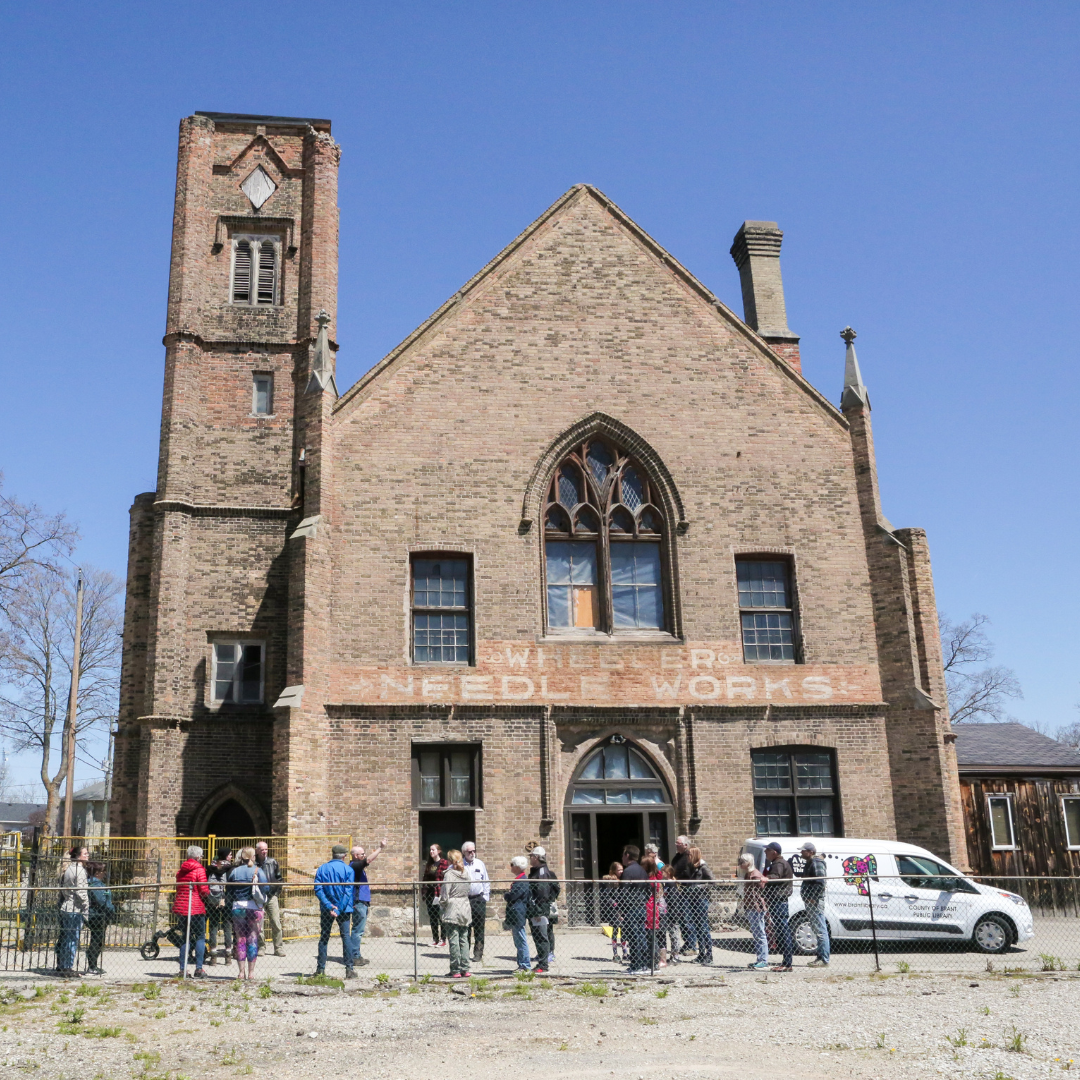A group of event-goers gather outside the Bawcutt Centre for a historical walking tour.