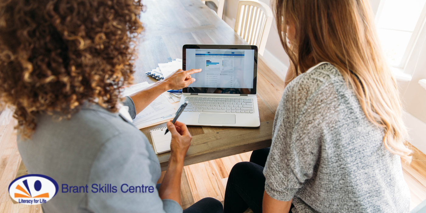 The backs of two women who sit at a table and appear to discuss what is on the screen of the tablet device in front of them. The Brant Skills Centre logo is featured in the bottom-left part of the image.