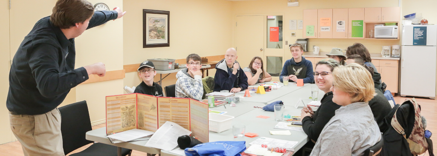 A group of teens sitting around a table playing Dungeons and Dragons.