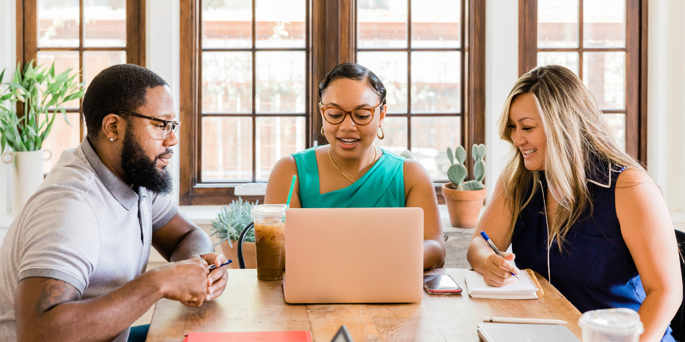 A diverse group of writers engaged in conversation around a table.