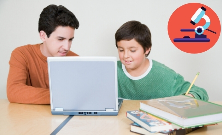 teen boy and child reading on a computer together